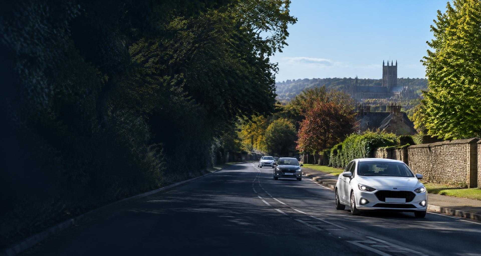 Cars travelling on a tree-lined road near Winchester